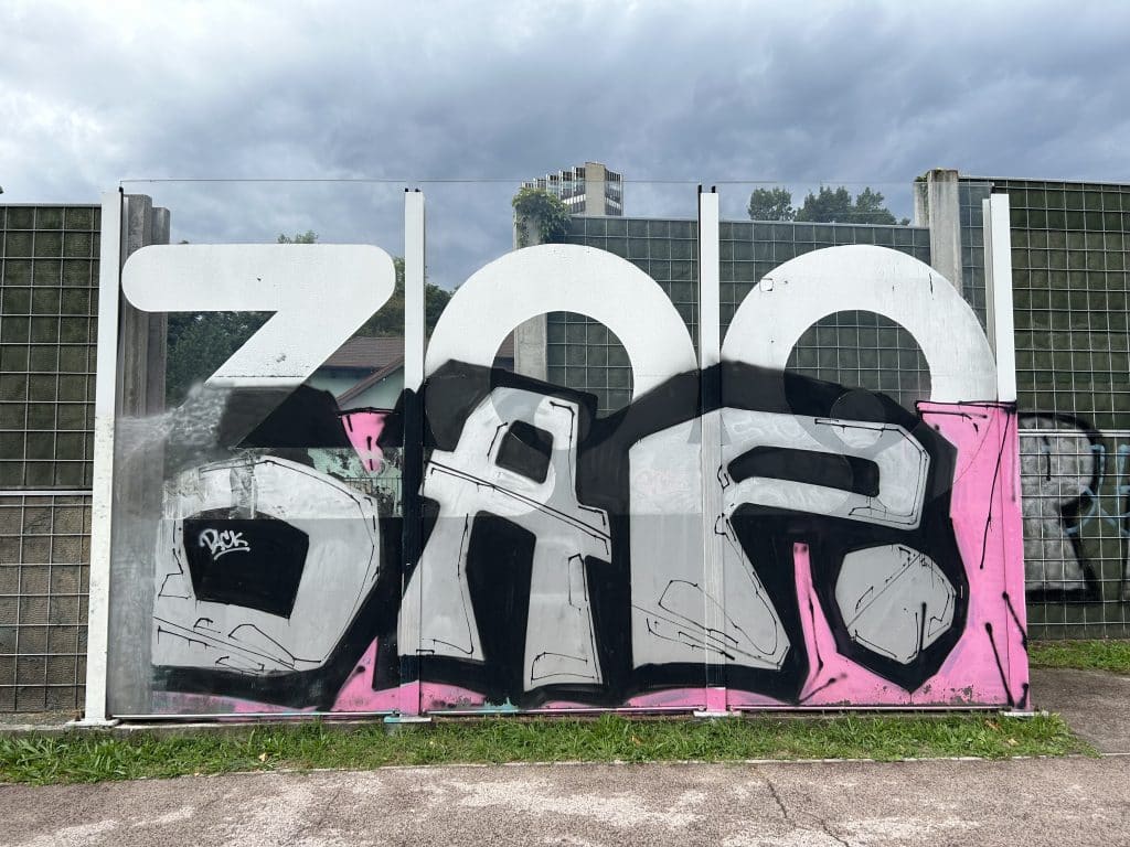 Záber na príjazdovú cestu do ZOO Bratislava. Na skle namaľovaný grafit.